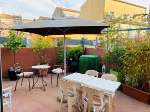 - une table, des chaises et un parasol sur la terrasse dans l'établissement Maison de maitre, coeur de ville., à Sète