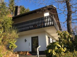 a white house with a balcony on top of it at Sauerland vakantiehuisje in Diemelsee