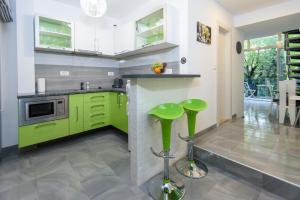 una cocina con armarios verdes y taburetes verdes en Apartments Mali Stradun, en Dubrovnik