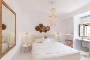 biała sypialnia z białym łóżkiem i lustrem w obiekcie Amalgam Homes Paros w mieście Ambelas