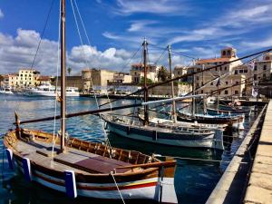 a group of boats are docked in a harbor at My Baby House in Alghero