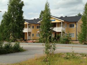 a large yellow building with a street in front at Huoneistohotelli Lumihovi in Jämijärvi