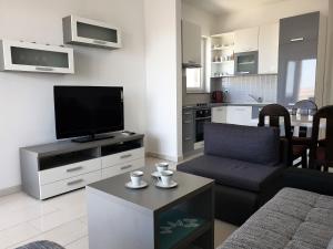 a living room with a flat screen tv and a couch at Apartment FERAL Novalja in Novalja