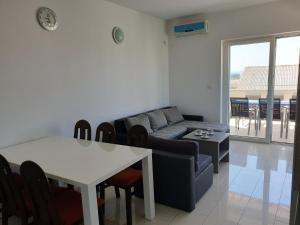 a living room with a couch and a table at Apartment FERAL Novalja in Novalja