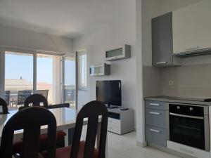 a kitchen with a table and chairs and a television at Apartment FERAL Novalja in Novalja