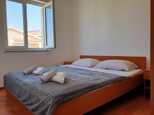 a bedroom with a bed with two pillows on it at Apartment FERAL Novalja in Novalja +5 photos