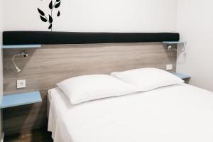 a bedroom with a white bed with a wooden headboard at Illyria Apartments in Skradin +16 photos