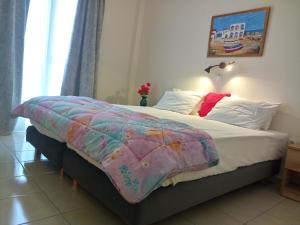 - une chambre avec un lit et une couverture colorée dans l'établissement Meletis Studios, à Parikia