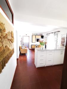 uma cozinha com armários brancos e piso em azulejo castanho em Apartamento Marysol na Nazaré