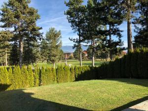 un giardino con siepi, alberi e erba di Pirin Golf and Spa Luxury Chalet a Bansko