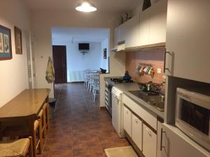 une cuisine avec des placards blancs, une table et une salle à manger dans l'établissement Pensiunea Simona, à Sîmbăta de Sus