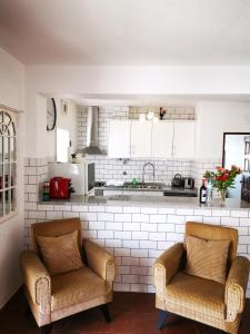 a kitchen with two chairs and a kitchen counter at Apartamento Marysol in Nazaré