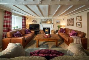 a living room with leather couches and a coffee table at Thornhill Lodge, Historic 4 Bed, 4 Ensuite in Stirling