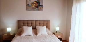 een slaapkamer met een bed met twee lampen op tafels bij Solaris Apartments in Šibenik