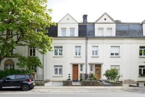 a car parked in front of a white house at CityStudios in Luxembourg