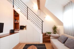 a living room with a couch and a staircase at CityStudios in Luxembourg