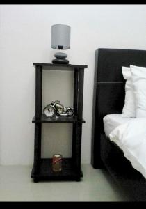 a black shelf with a clock on it next to a bed at Estien’s Cozy Condotel to Stay in Imus