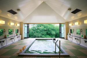 a swimming pool in a room with a large window at Kyoto Utano Youth Hostel in Kyoto