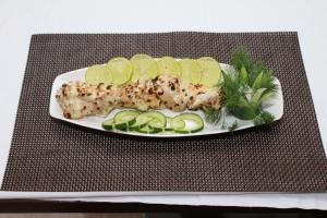 a plate of food with fish and lemon slices at Staylite Suites in Chennai