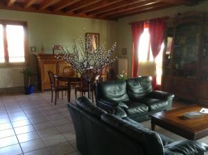 a living room with leather couches and a table at Croix Blanche in Cellieu