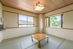 ein Raum mit einem Tisch und zwei Fenstern in der Unterkunft Hotel Tagawa in Yamanouchi + 70 Fotos