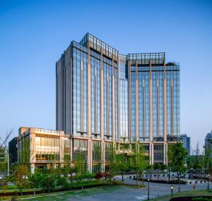 a rendering of a tall glass building at New World Guiyang Hotel in Guiyang
