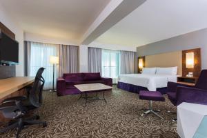 um quarto de hotel com uma cama, uma secretária e cadeiras em Krystal Urban Monterrey San Jeronimo em Monterrey