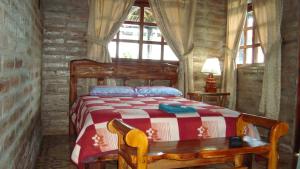 a bedroom with a bed in a log cabin at EL DESCANSO “the Rest” in Otavalo