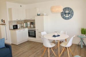 a kitchen and dining room with a table and chairs at Vier Jahreszeiten Haus 2 Whg 65 in Großenbrode