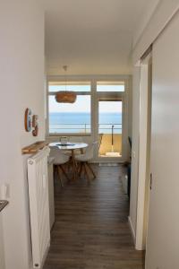 a dining room with a table and a view of the ocean at Vier Jahreszeiten Haus 2 Whg 65 in Großenbrode