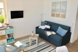 a living room with a blue couch and a tv at Vier Jahreszeiten Haus 2 Whg 65 in Großenbrode