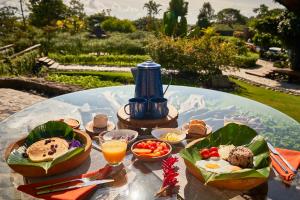 einen Tisch mit Essen und einen Wasserkocher mit blauem Tee in der Unterkunft Ecolirios Boutique Hotel and Spa in Guácimo