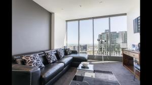 a living room with a leather couch and large windows at Fantastic Freshwater in Melbourne