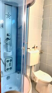 a bathroom with a toilet and a glass shower at Vila Nicoleta in Băile Olăneşti