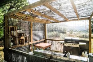 an outdoor kitchen with a table and a grill at Mt Gold Glamping in Wanaka