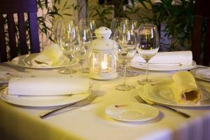 - une table avec des verres à vin ainsi que des assiettes et des serviettes blanches dans l'établissement Hotel Spa La Casa Del Convento, à Chinchón