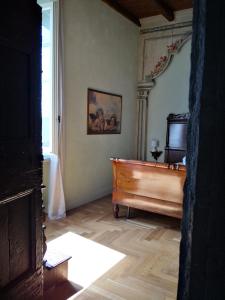 sala de estar con suelo de madera y piano en B&B Dimora Delle Donnole Bergamo Alta, en Bérgamo