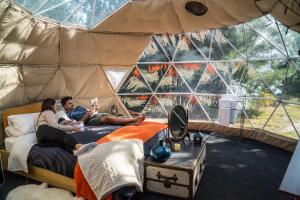 eine Gruppe von Personen, die in einem Zelt auf Betten liegen in der Unterkunft Mt Gold Glamping in Wanaka