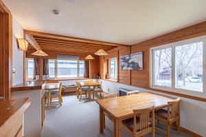 comedor con paredes de madera, mesas y ventanas en North Point, en Niseko