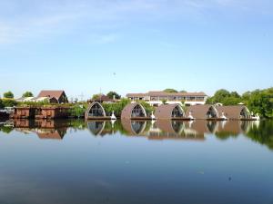 un reflejo de casas en el agua con un puente en schwimmendes Seehotel, en Parey