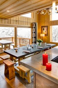 un comedor con una mesa con velas rojas en Le Grand Canyon, en Les Gets