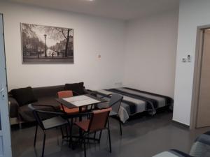 a room with a couch and a table and chairs at Kertvárosi Apartman in Tiszaújváros