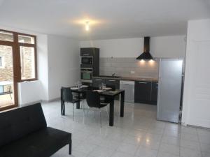 a kitchen and dining room with a table and chairs at gite Oustal in Belcastel +3 photos