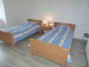 two beds in a room with two lamps on a table at gite Oustal in Belcastel