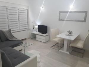 uma sala de estar com um sofá, uma mesa e uma televisão em Apartment Kristina em Otočac