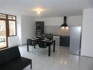 a kitchen with a table and chairs in a room at gite Oustal in Belcastel