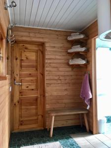 a wooden sauna with a wooden door and a bench at Heinaka Kodu in Rakvere