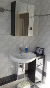 a bathroom with a white sink and a mirror at Ferienhaus Mina im Harz in Stapelburg +23 photos
