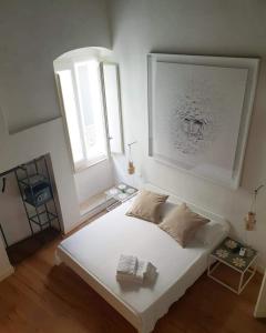 Una cama blanca en una habitación con ventana. en Orazio33 b&b, en Monopoli