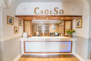 a woman sitting at a counter in a store at Atlantic Hotel in Tenby